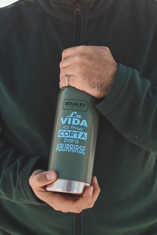 人的手拿着斯坦利la Vida Es Muy Corta Para Aburrirse瓶 · 免费素材图片