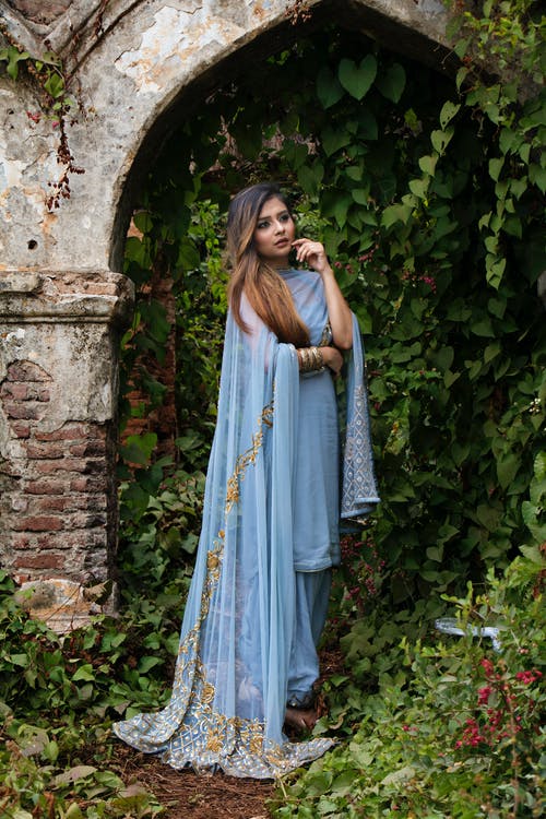 站在混凝土乔木包围藤蔓下的女人 · 免费素材图片