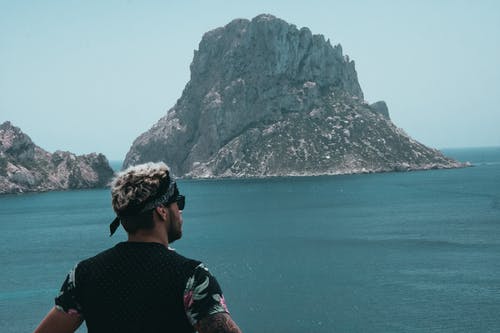 男人看着大洋彼岸的山 · 免费素材图片