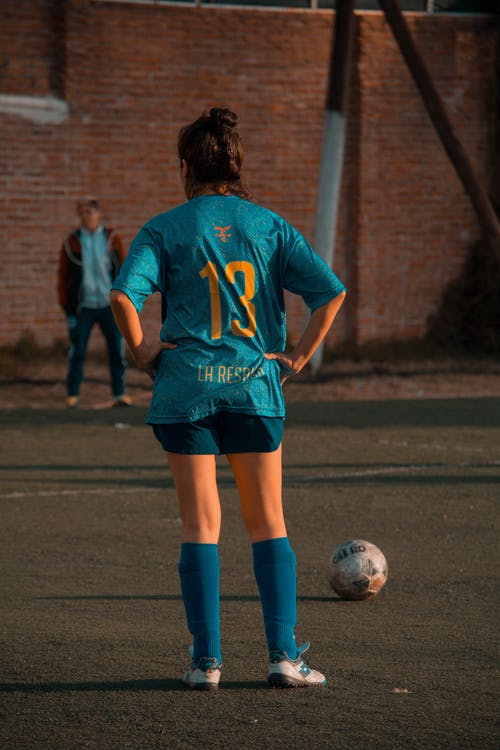 蓝色足球球衣站在球前的人 · 免费素材图片