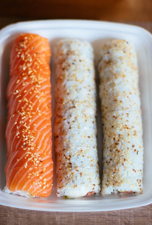 白色塑料容器中的三个寿司卷 · 免费素材图片