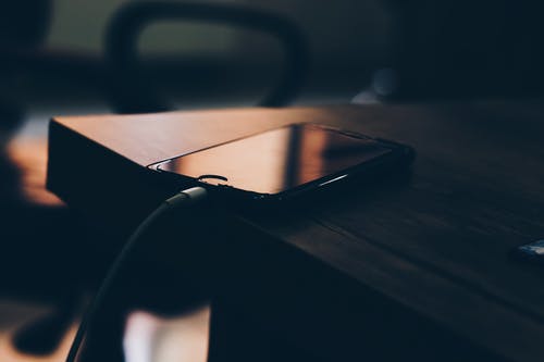 黑色iphone 7棕色木制的桌子上的浅焦点摄影 · 免费素材图片