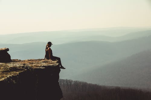 女人坐在岩层的边缘 · 免费素材图片