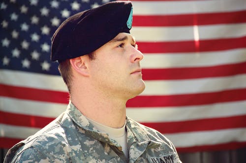 男子戴着作战帽和顶部查找附近美国国旗 · 免费素材图片