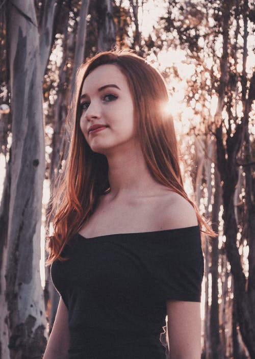 在树附近穿黑色抹胸连衣裙的女人 · 免费素材图片