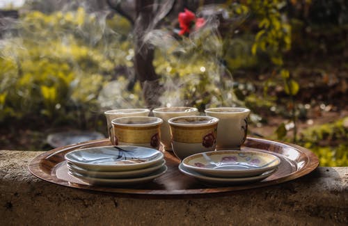 白色花茶茶杯和茶碟棕色木制托盘上 · 免费素材图片