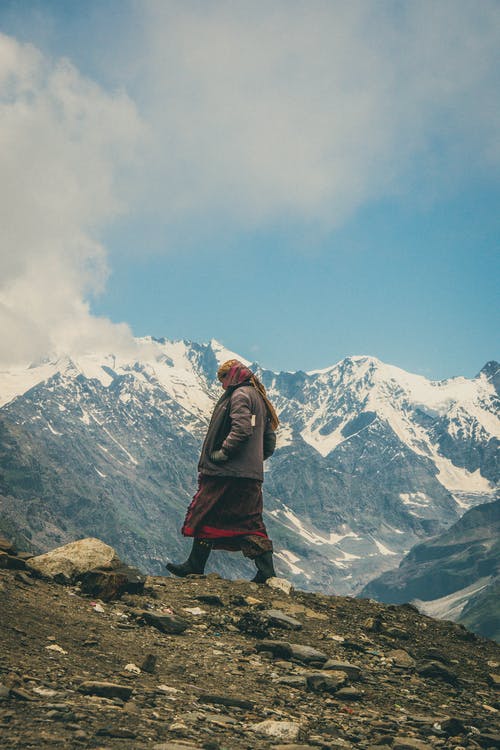 站在雪山附近的棕色外套的人 · 免费素材图片