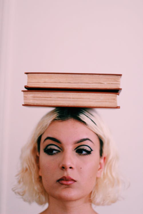 两本书在女人的头上 · 免费素材图片