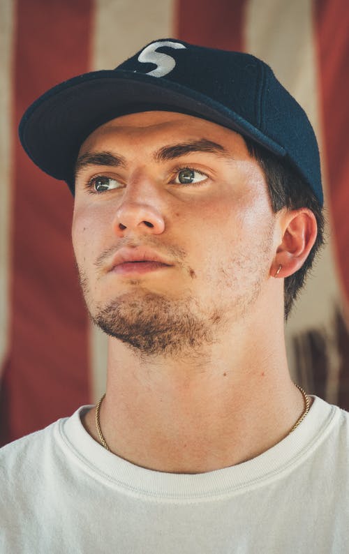 男子身穿蓝帽和圆领衬衫 · 免费素材图片