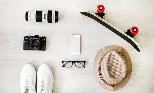 黑色滑板，白色iphone 5，棕色帽子，黑色傻瓜相机和变焦镜头的摄影 · 免费素材图片