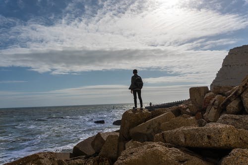 站在海边岩石上的人 · 免费素材图片