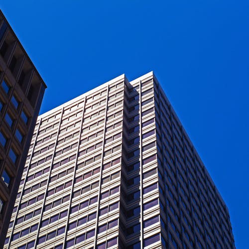 蓝蓝的天空下的白色混凝土建筑的低角度照片 · 免费素材图片