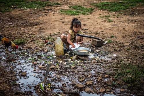 坐在塑料瓶附近的女孩洗碗 · 免费素材图片