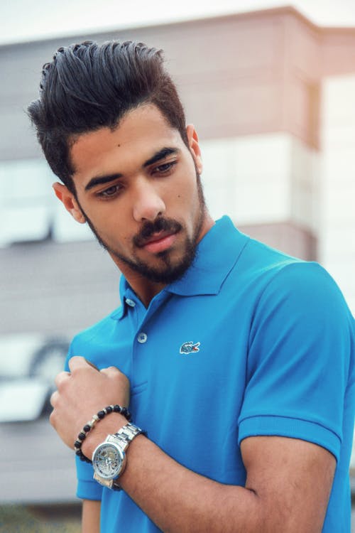男人穿着蓝色lacoste Polo衫和银色模拟手表 · 免费素材图片