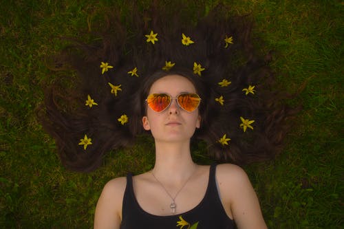 铺设在草坪上的女人戴着飞行员太阳镜 · 免费素材图片