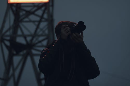 男子手持单反相机的剪影摄影 · 免费素材图片