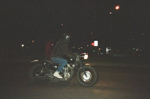 夜间在公路上骑摩托车的人 · 免费素材图片