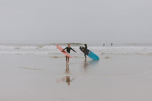 人在海边举行冲浪板摄影 · 免费素材图片