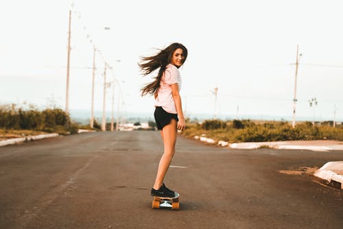 在这条路的女人骑滑板 · 免费素材图片