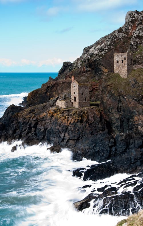 白天在海边悬崖上的两个灰色砖watch望塔 · 免费素材图片