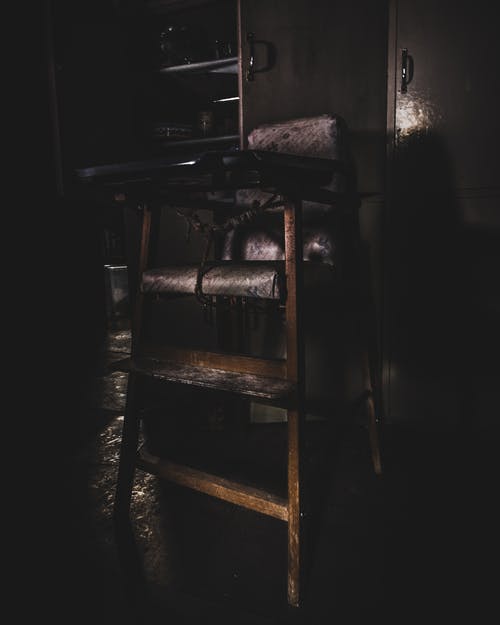 婴儿的木制高脚椅在昏暗的灯光下 · 免费素材图片
