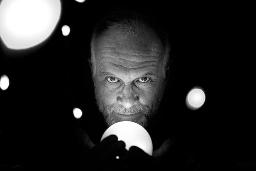 该名男子手持光的灰度照片 · 免费素材图片