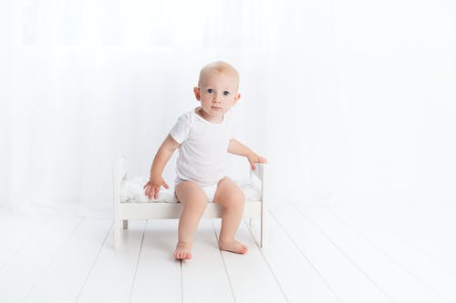 婴儿坐在长椅上 · 免费素材图片