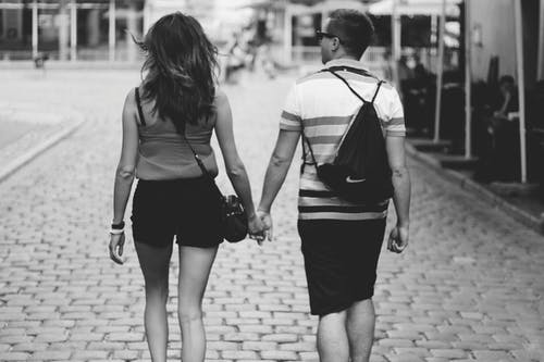 男人和女人走路时手牵着手的灰度摄影 · 免费素材图片