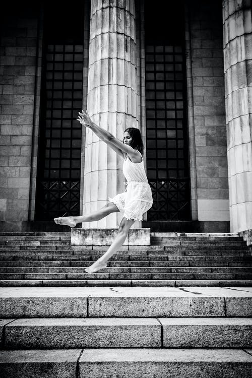 女人在楼梯上跳舞的灰度照片 · 免费素材图片
