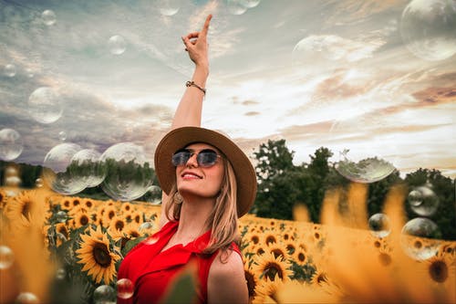 向日葵包围举手的女人 · 免费素材图片