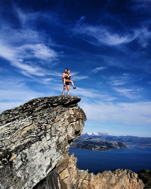 两人在悬崖上的风景摄影 · 免费素材图片