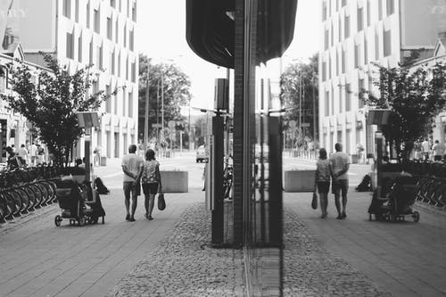男人和女人在街上散步的灰度摄影 · 免费素材图片