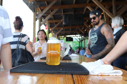 啤酒杯与桌上的啤酒 · 免费素材图片