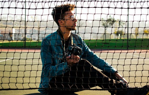 男子坐在网球场上的照片 · 免费素材图片