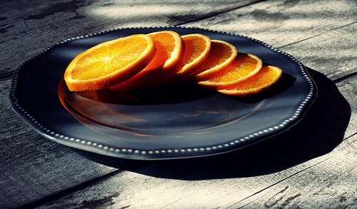 黑色陶瓷板上的六片橙子 · 免费素材图片