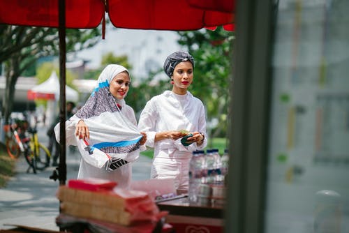 两个女人在买街头食品 · 免费素材图片