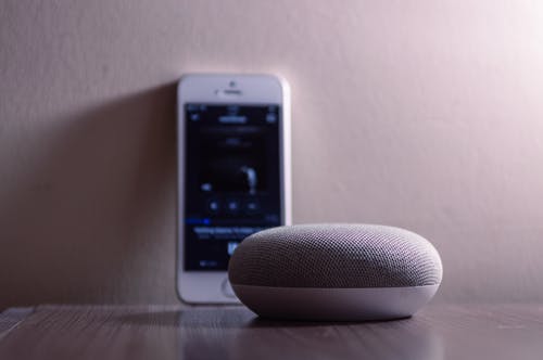 银色iphone 5s旁边的灰色google Home Mini · 免费素材图片