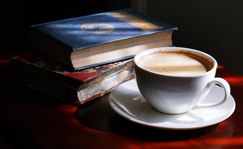 书旁的白色茶杯和茶碟 · 免费素材图片