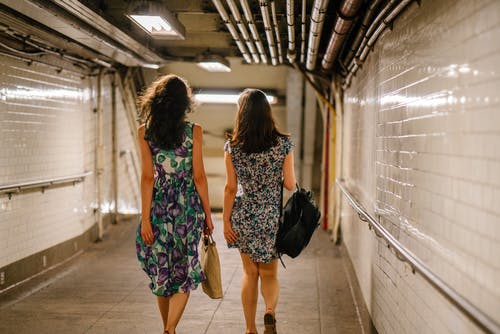 两个女人在隧道里走路时背着书包 · 免费素材图片