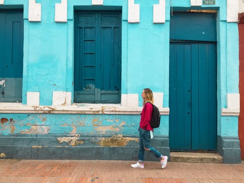 女人步行街与蓝色建筑 · 免费素材图片