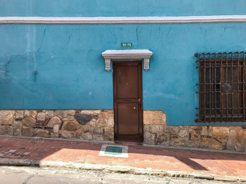 空人行道旁的棕色木制关闭门 · 免费素材图片