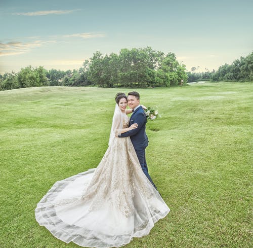 新娘和新郎站在绿色的草地上 · 免费素材图片