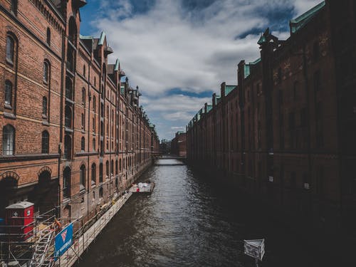 两座棕色砖砌建筑物之间的运河 · 免费素材图片