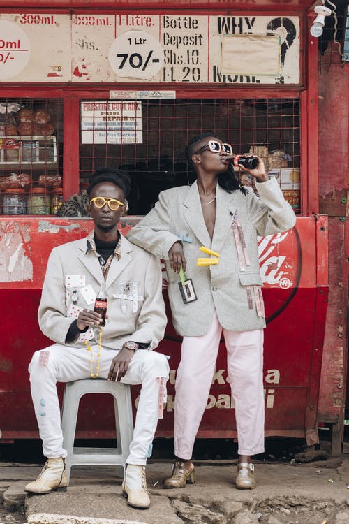 两名男子在可口可乐摊位附近喝可口可乐 · 免费素材图片