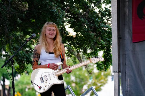 女人抱着白色的电吉他 · 免费素材图片