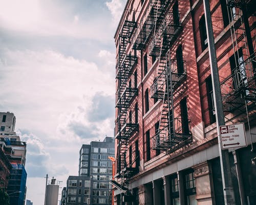 多云的天空下的棕色混凝土建筑 · 免费素材图片