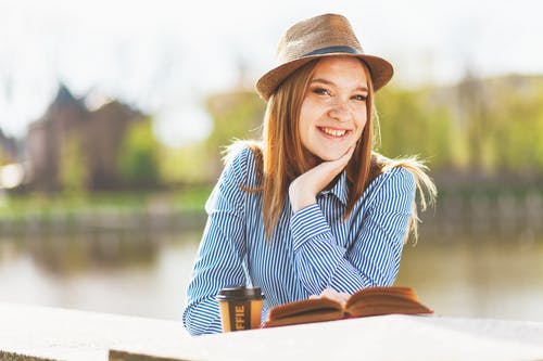 读书时的焦点摄影微笑的女人 · 免费素材图片