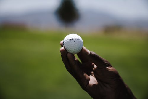 拿着高尔夫球的人的选择聚焦摄影 · 免费素材图片