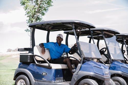 男子骑着高尔夫球车 · 免费素材图片