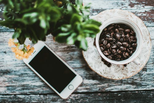 关闭了一杯烘焙咖啡豆附近的银色iphone 5s · 免费素材图片